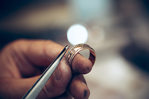 placing diamond into ring with tweezers